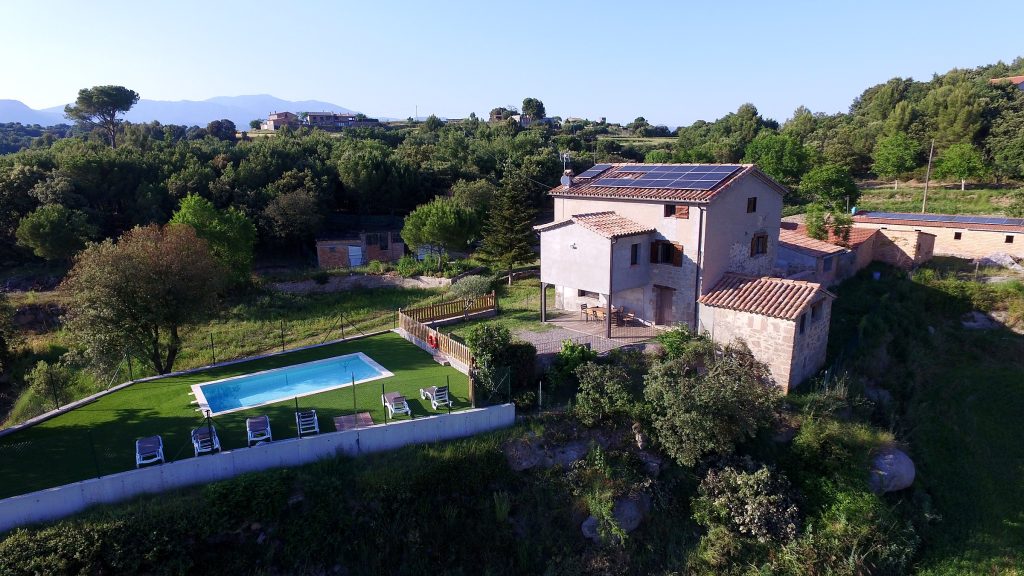 Cal Trumfet amb la piscina i la serra al fons, vistes des de l'aire