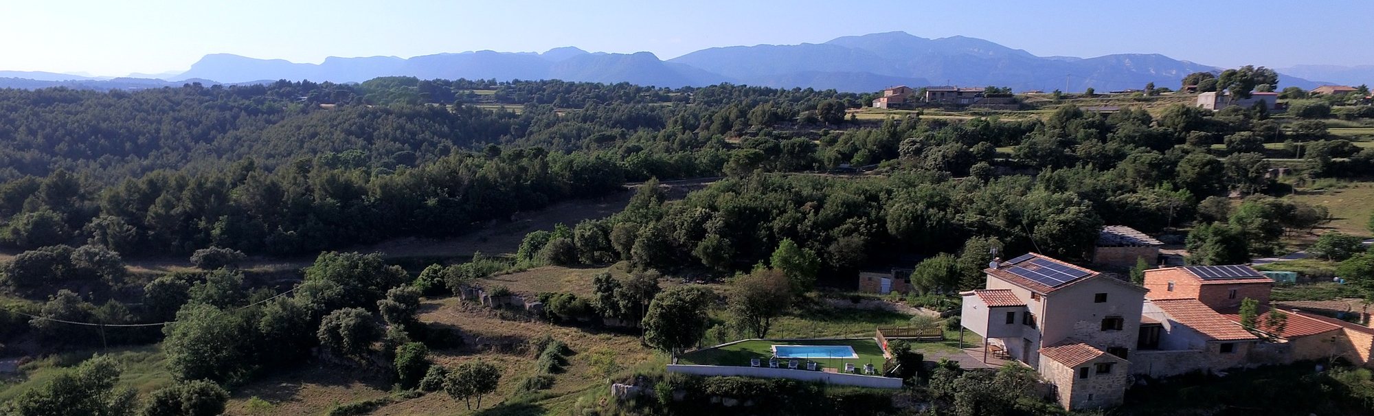 Vista aèria de la serra, el bosc i Cal Trumfet al Berguedà